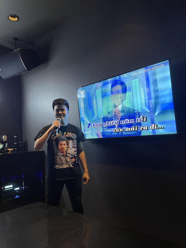 Johan singing karaoke in front of a lyrics screen