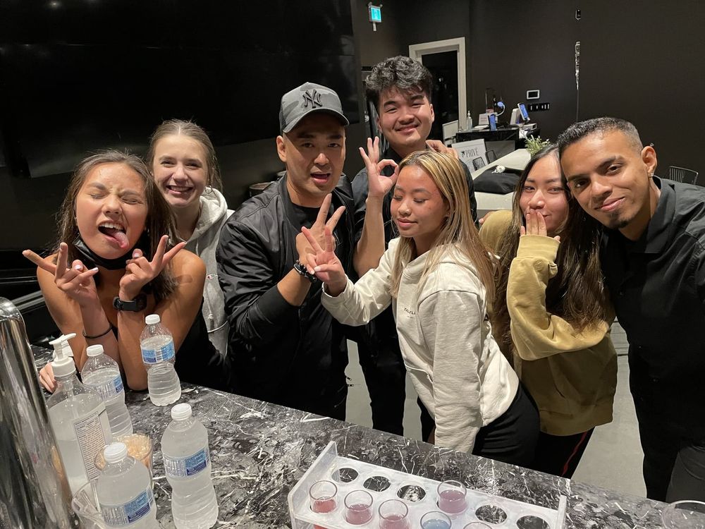Johan with the karaoke bar team posing and making hand signs