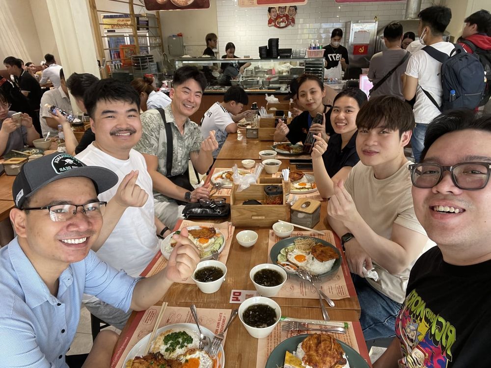 Johan and the Vietnam team eating together at a long restaurant table